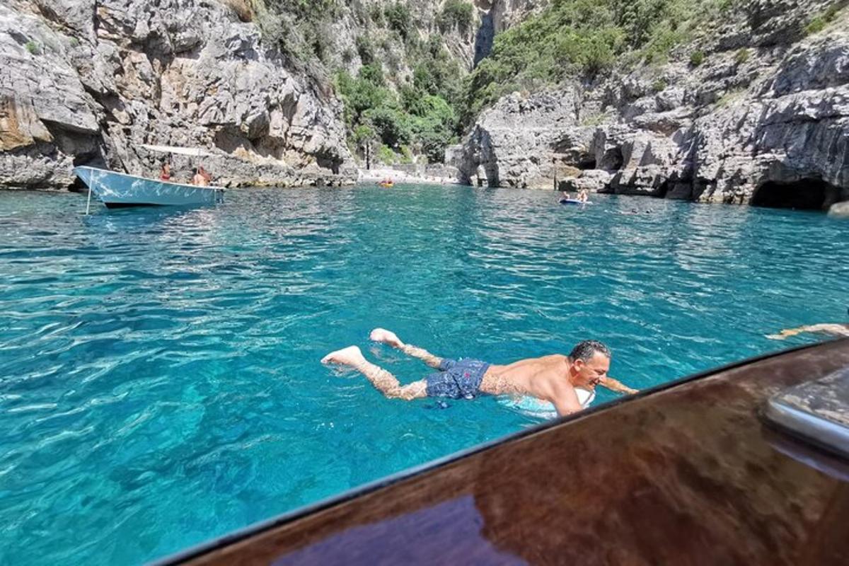 a man laying in the water next to a boat