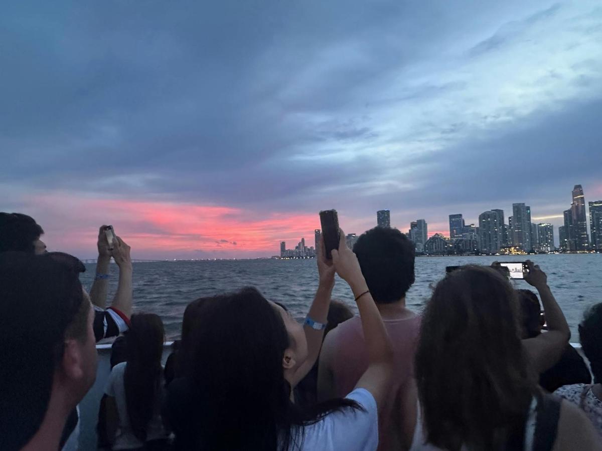 un grup de persones fent fotos de la ciutat des d'un vaixell