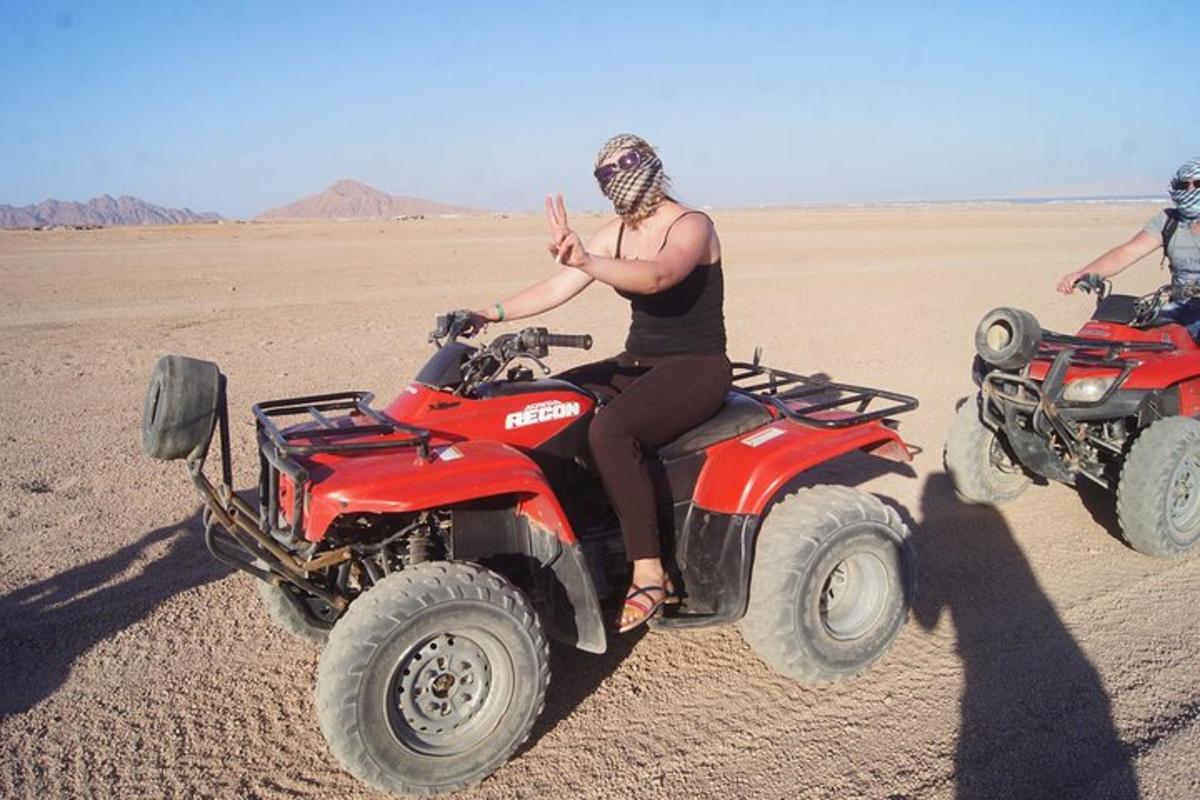 uma mulher sentada em um quadriciclo no deserto