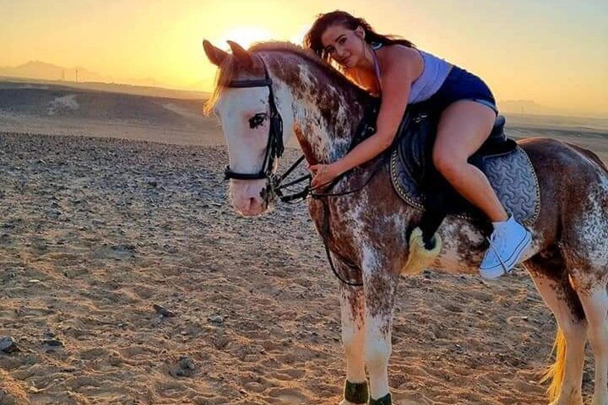 žena jedoucí na koni na pláži