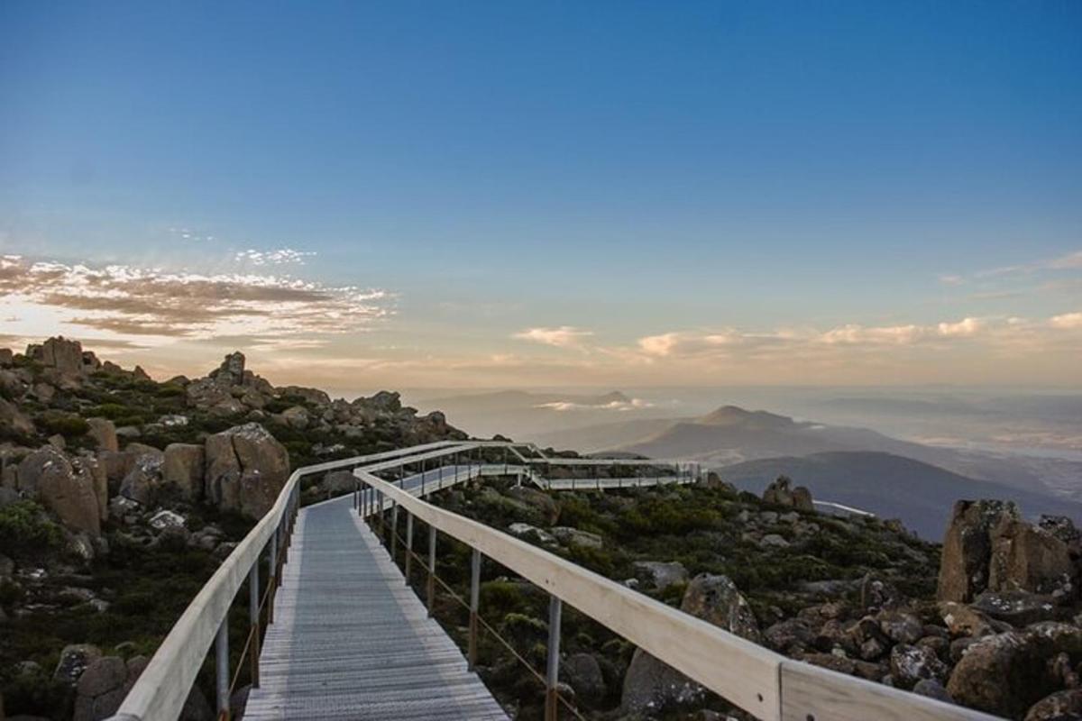 a wooden boardwalk on a mountain with a view