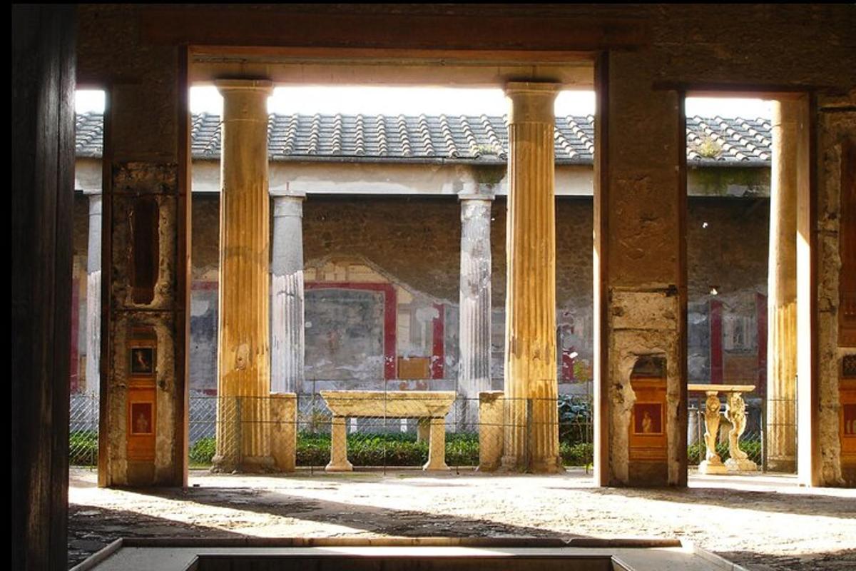 a room with columns and a bench in a building