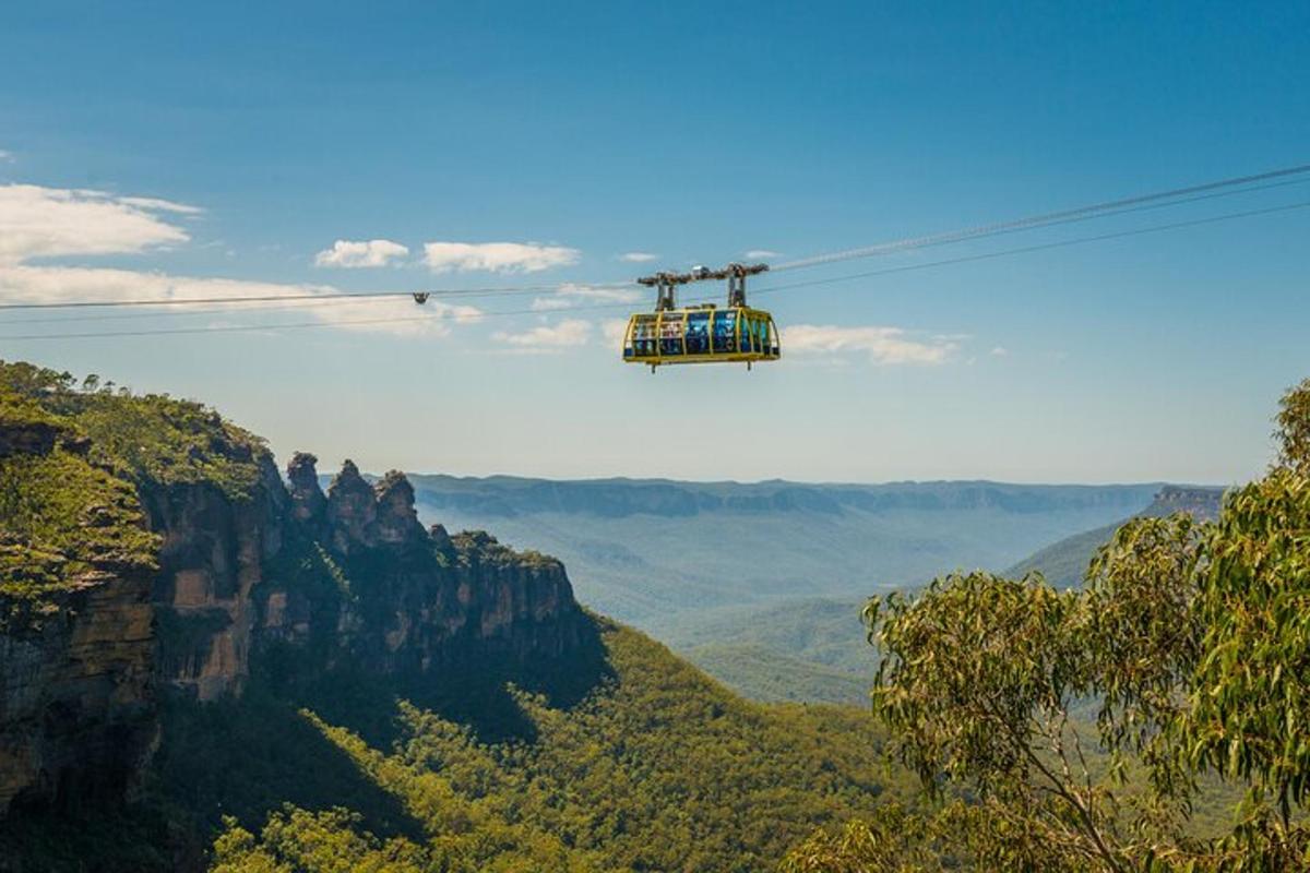 a cable car flying over the blue mountains