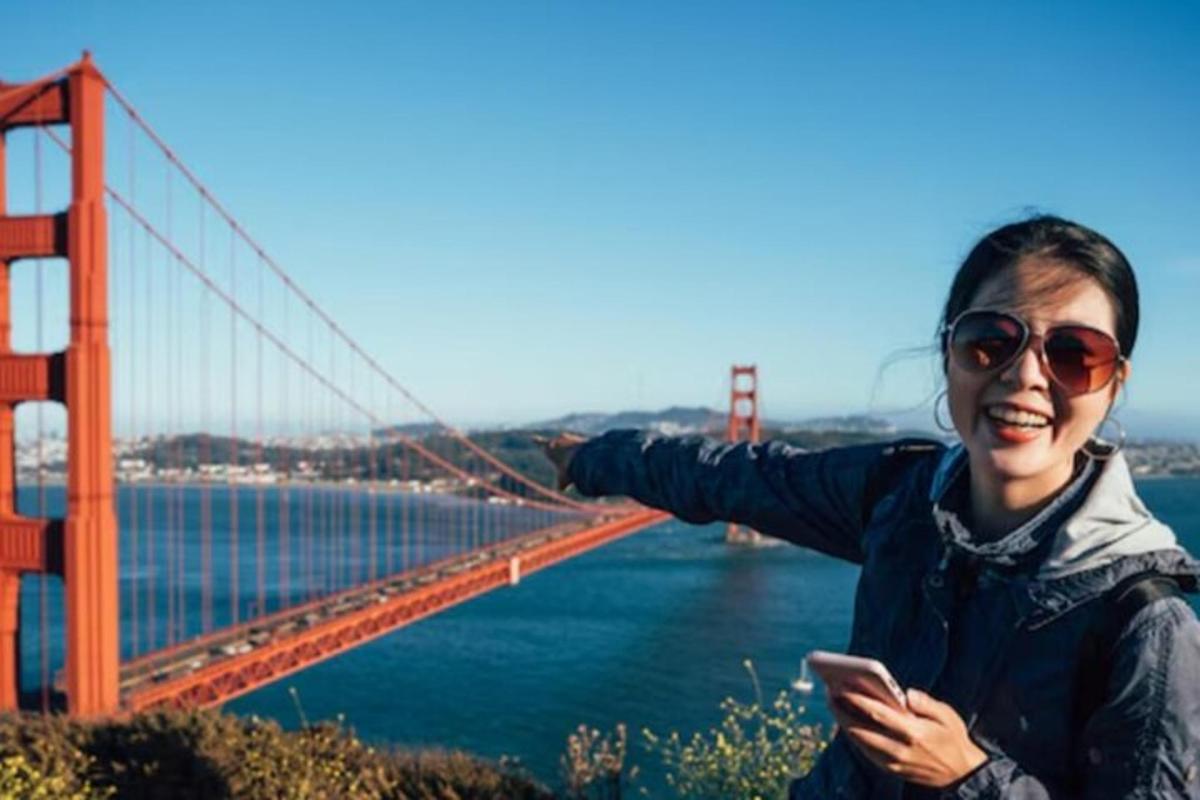 egy nő áll a Golden Gate híd előtt