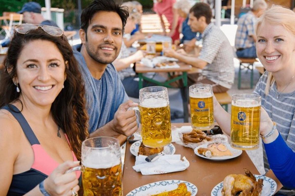 skupina ljudi, ki sedijo za mizo in pijejo pivo