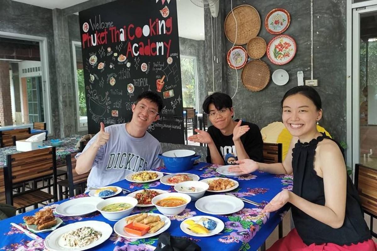 un gruppo di tre persone sedute a un tavolo con del cibo