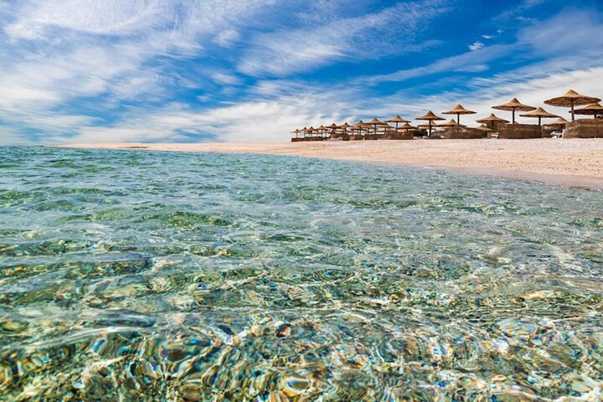a beach with umbrellas and the clear water