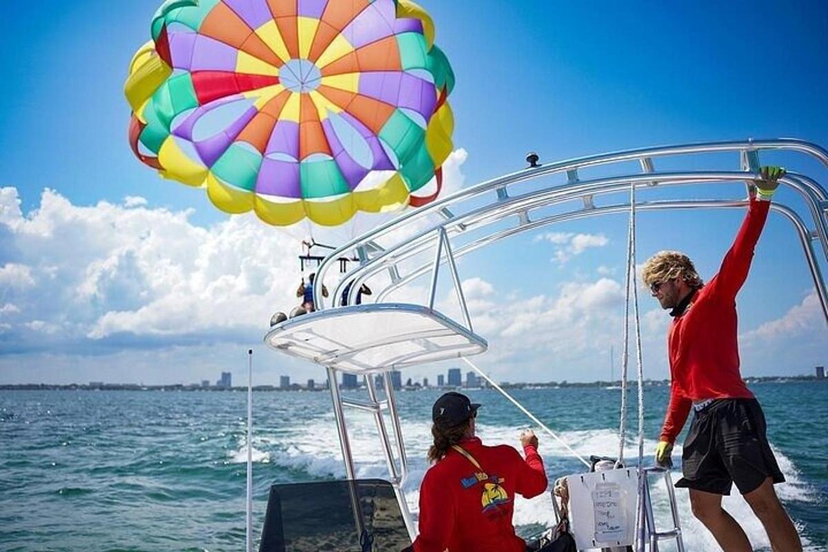 Una pareja de personas en un barco con un paracaídas.