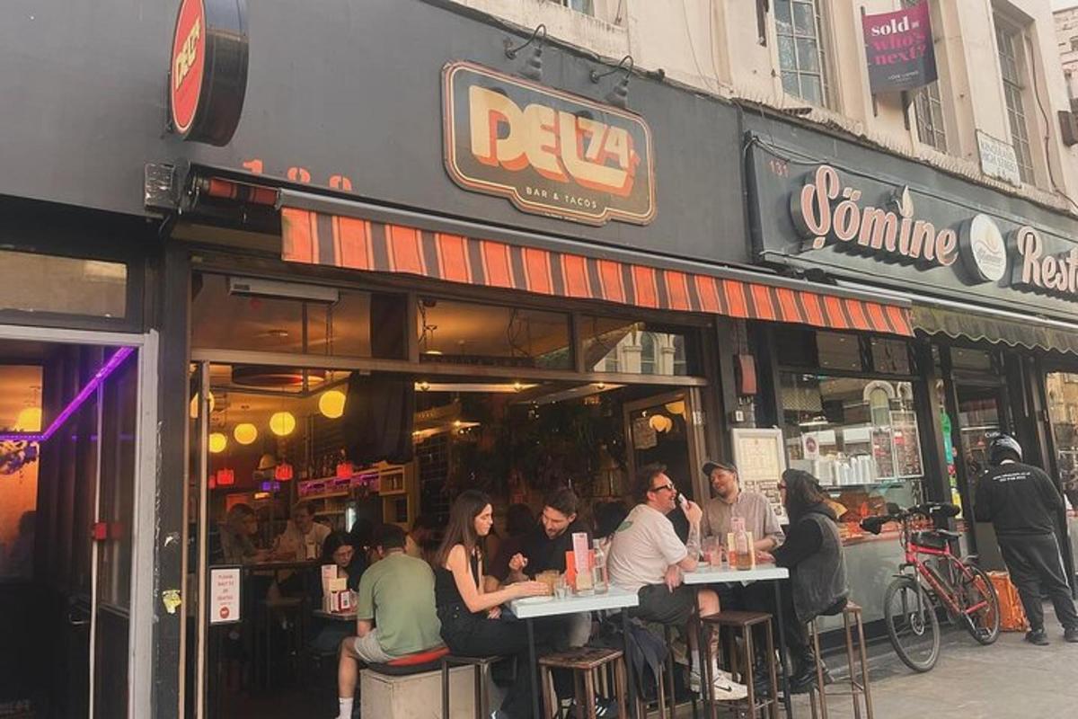 un grup de oameni așezați la mese în afara unui restaurant