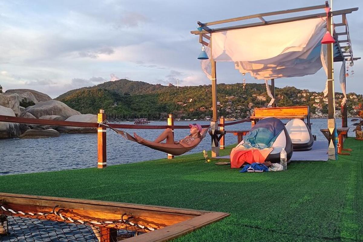 a person sleeping in a hammock next to a body of water