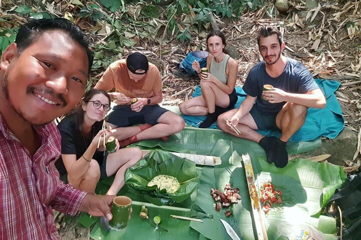a group of people sitting on the ground eating food