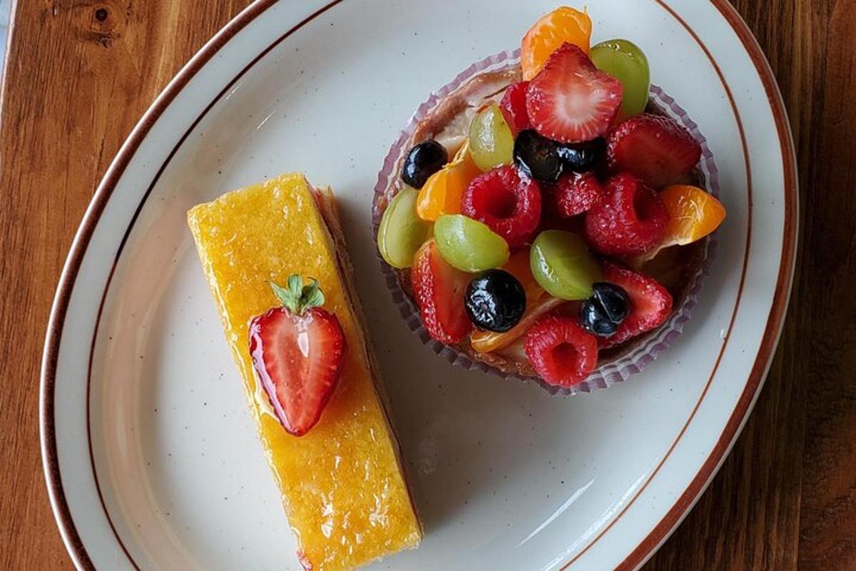 a plate with a bowl of fruit and a piece of cake