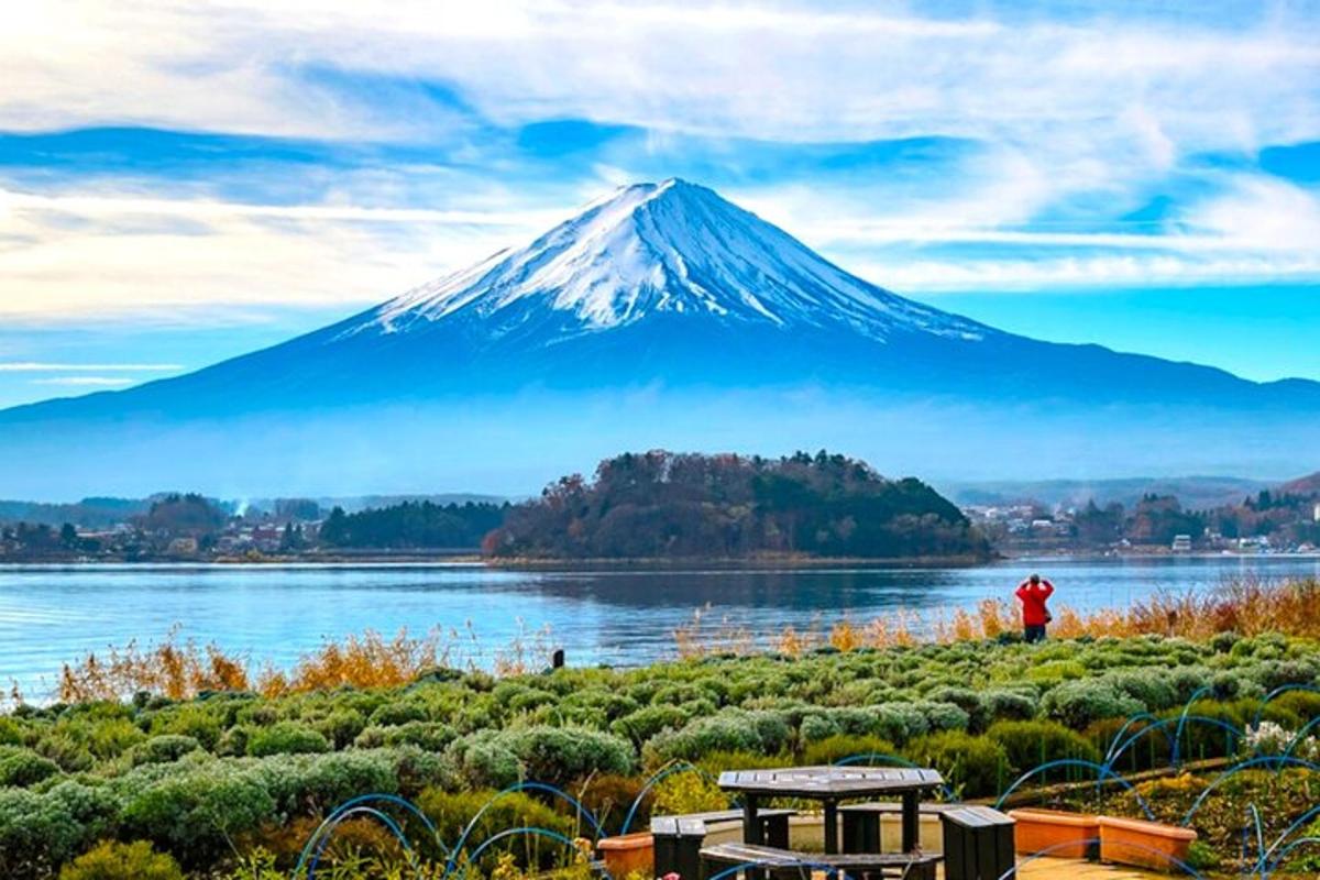 a mountain with a person standing in front of a lake