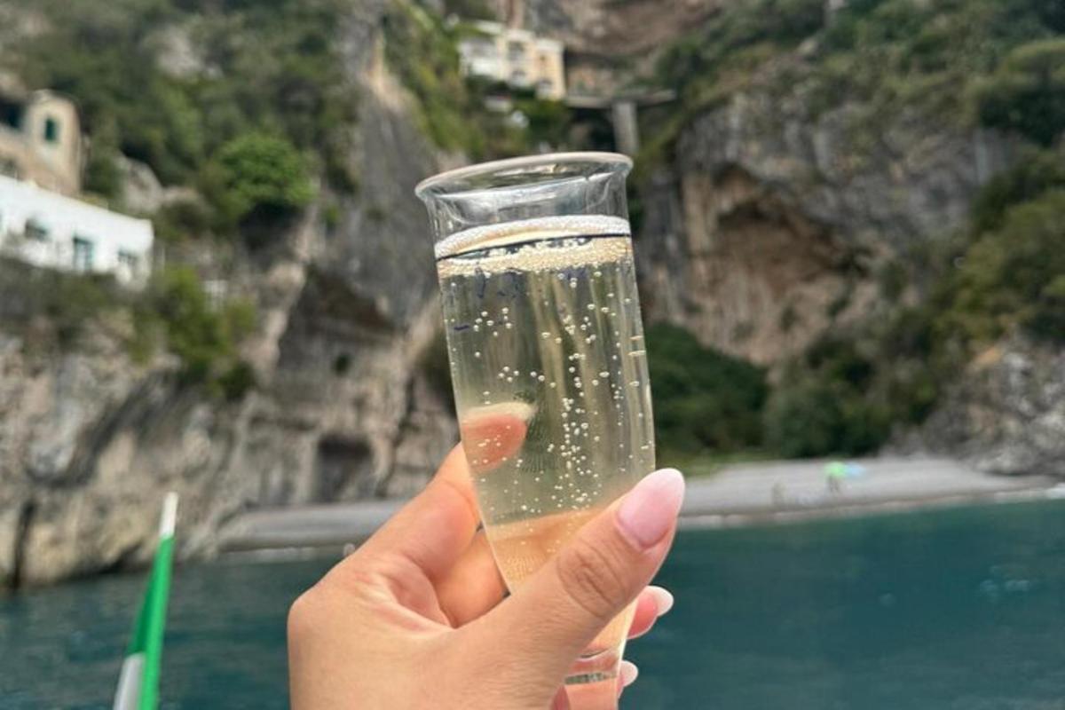 una persona che regge un bicchiere di champagne