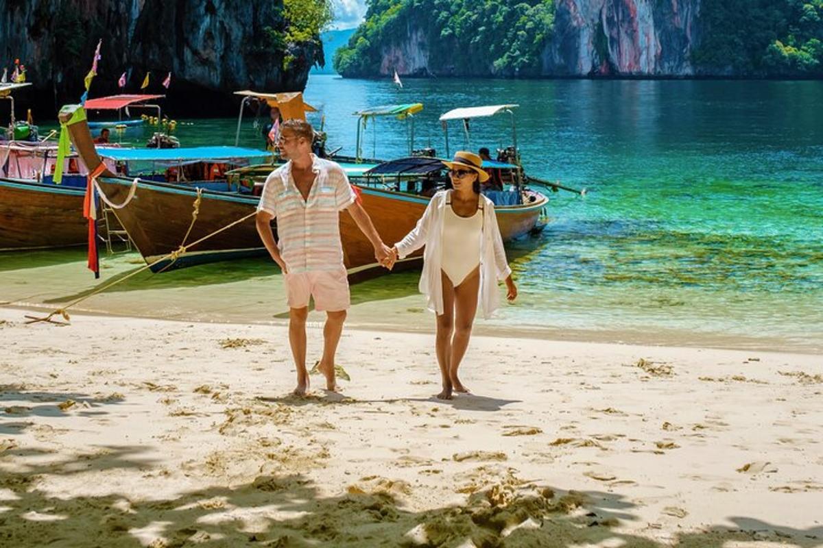 a man and woman walking on a beach with a boat