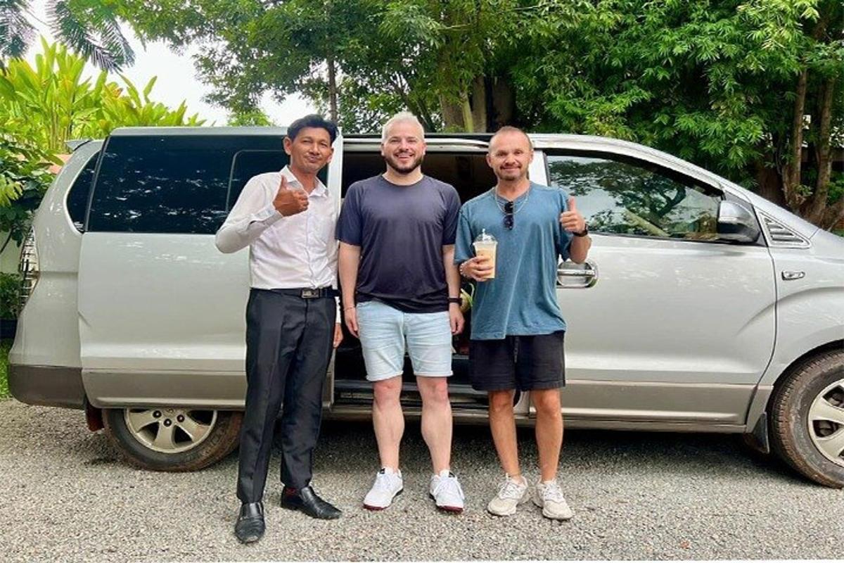 three men are standing in front of a car