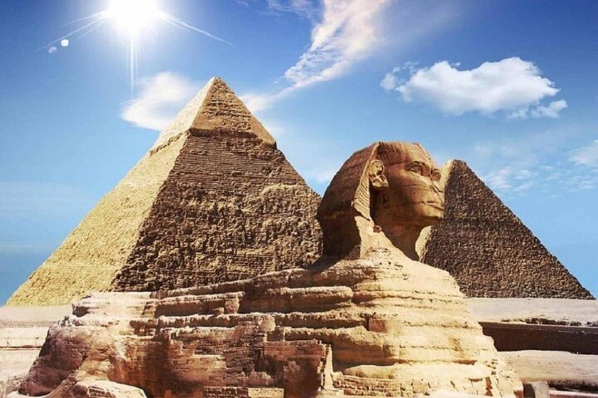 uma estátua em frente às pirâmides