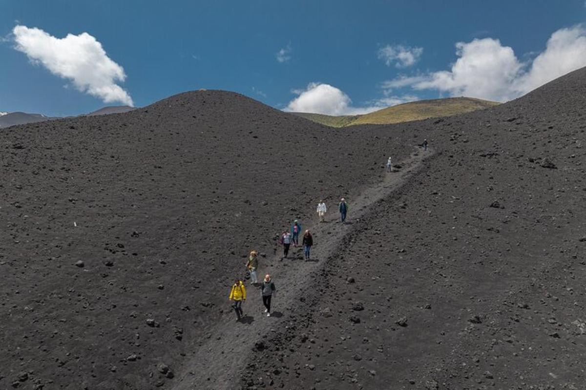 un gruppo di persone che camminano su una collina sterrata