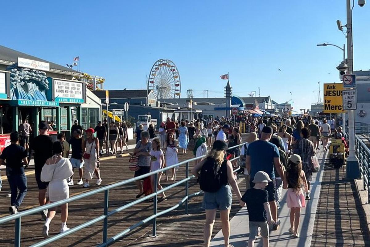 en stor folkmassa som går på en strandpromenad