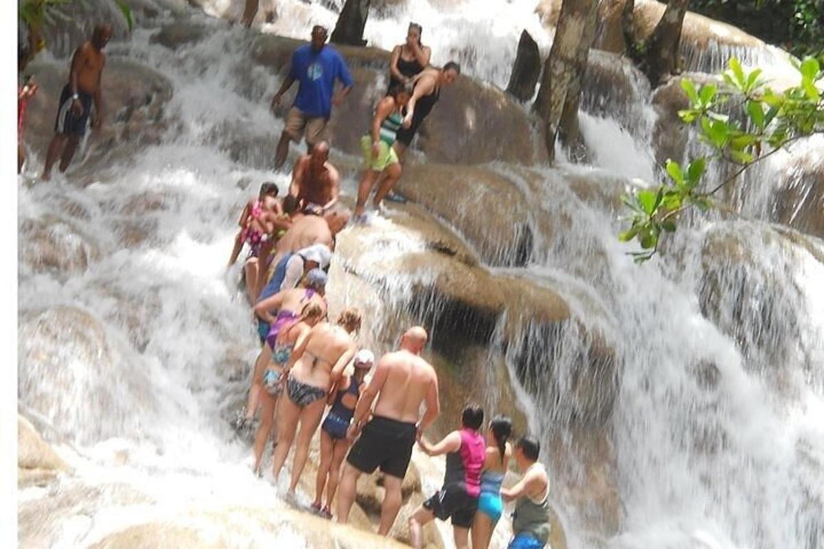 sekumpulan orang berdiri di tepi air terjun