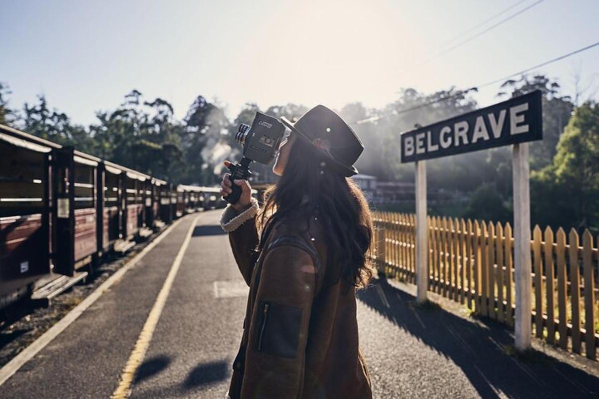 ženska, ki s fotoaparatom fotografira ulični znak