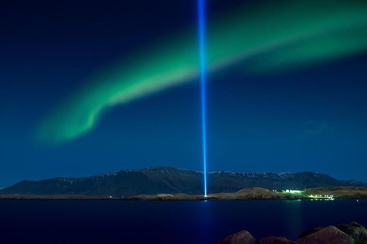 una aurora brilla al cel sobre una massa d'aigua