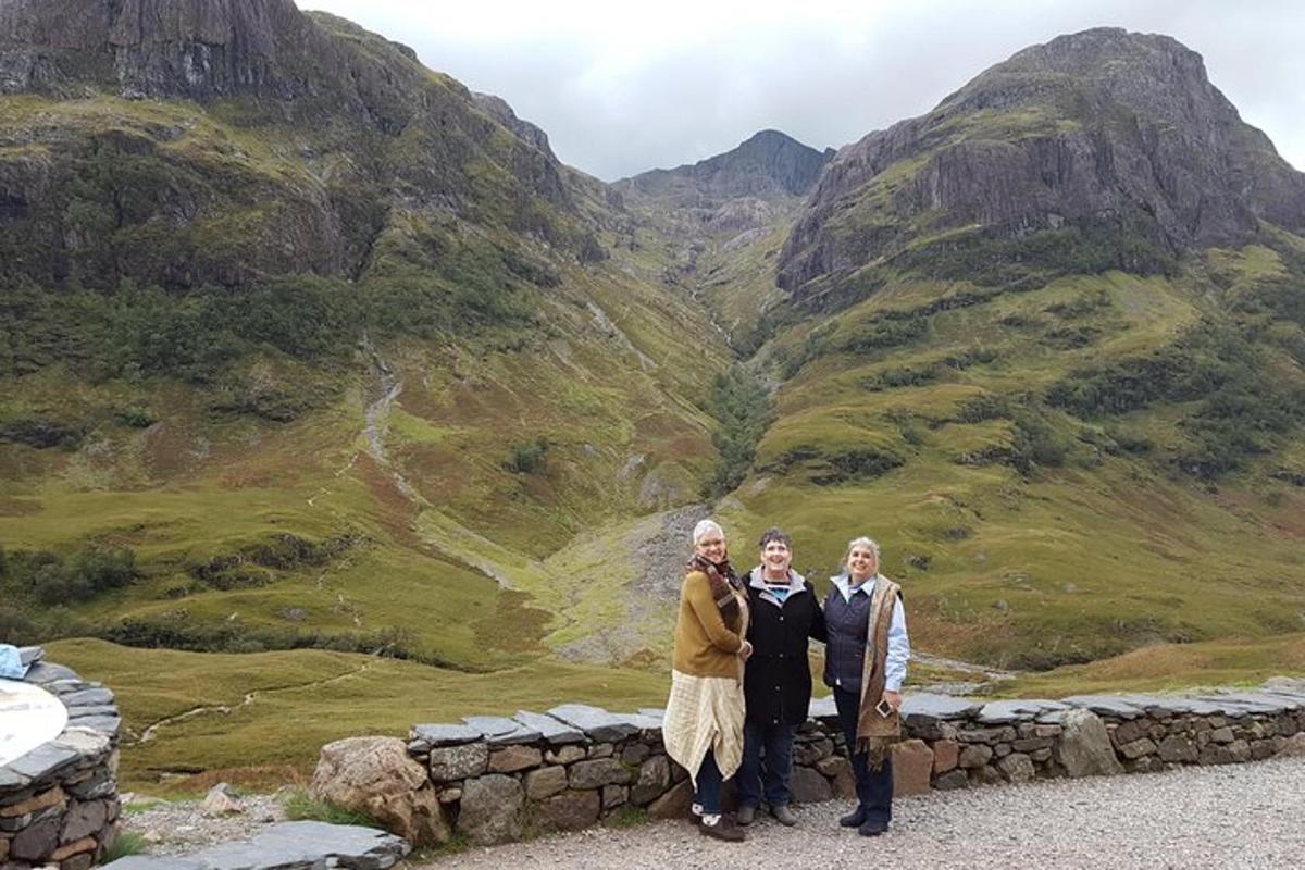 un gruppo di tre persone in piedi di fronte a una montagna