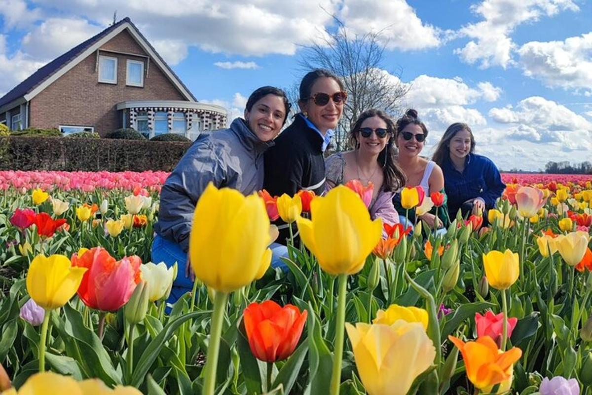 a group of people standing in a field of tulips