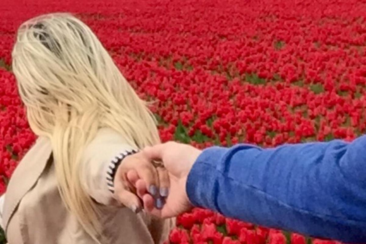 a couple holding hands in a field of tulips