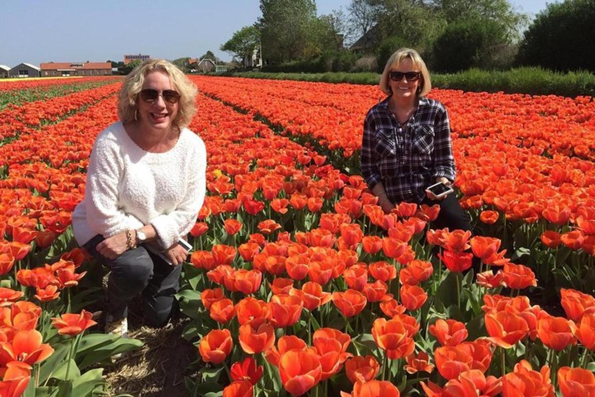two women kneeling in a field of tulips