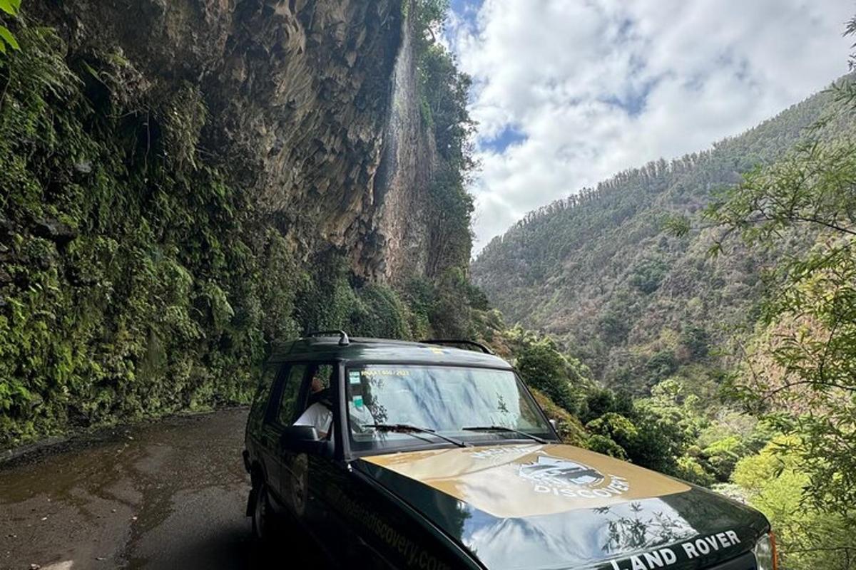 a truck driving down a dirt road in a mountain