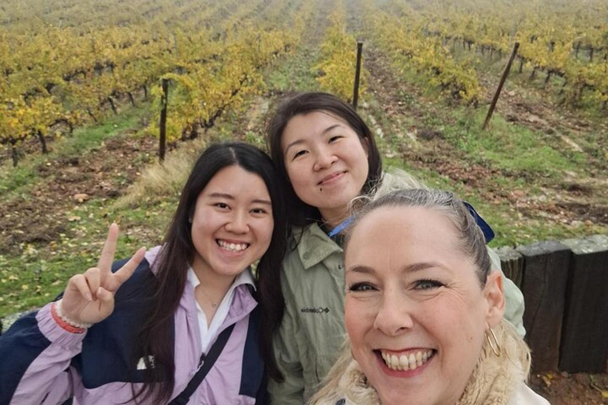 tiga wanita bergambar di hadapan ladang anggur