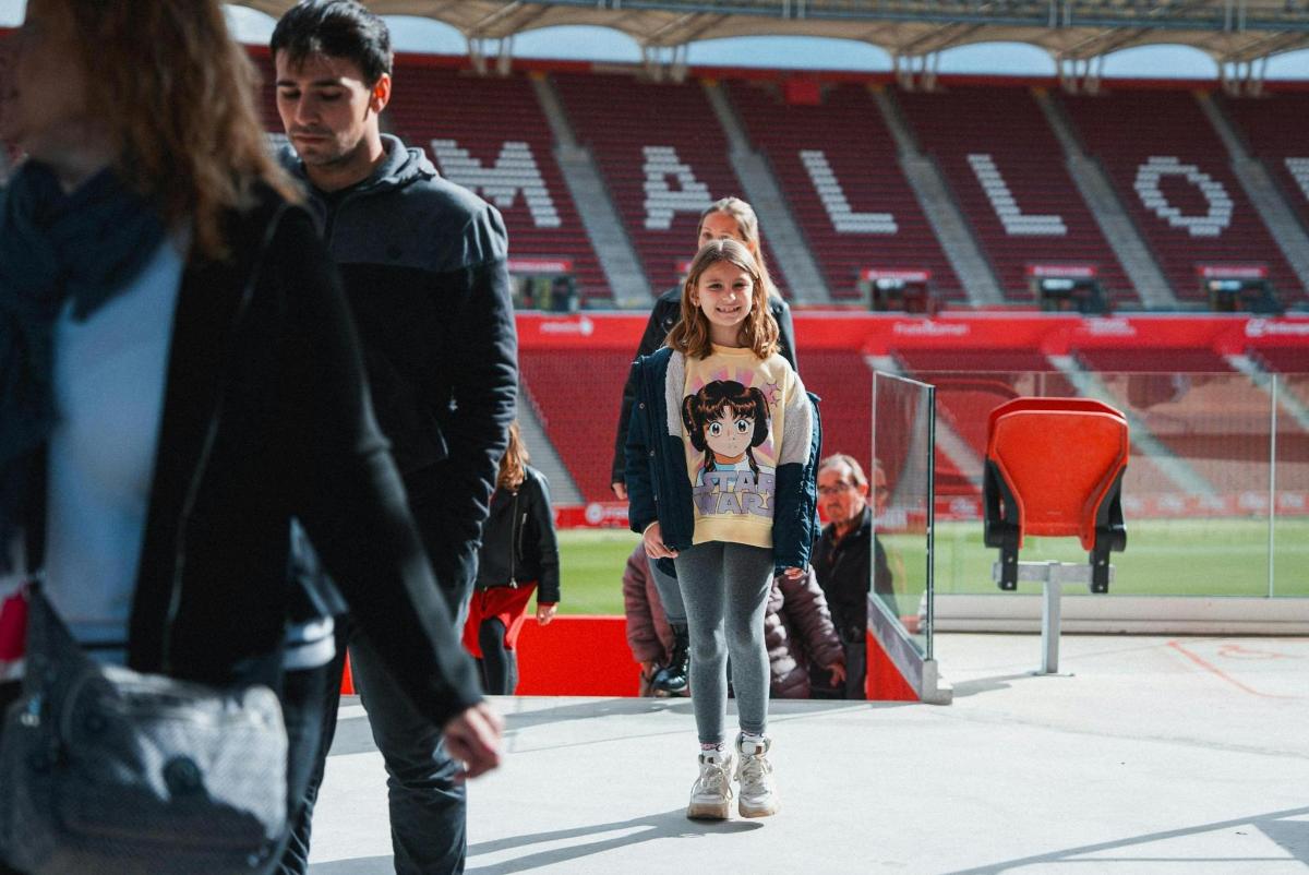 a young girl walking in front of a stadium