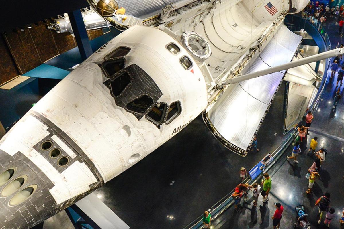 skupina lidí stojících před raketoplánem