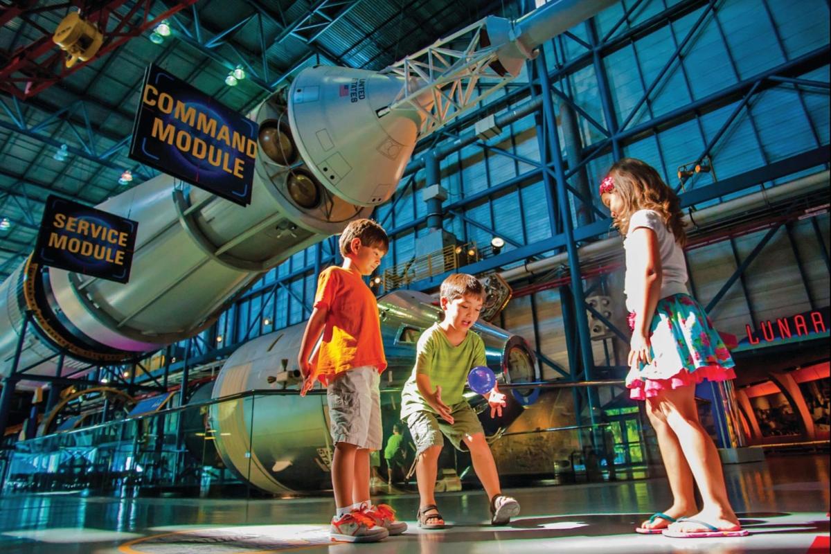 um grupo de crianças em frente a um museu espacial