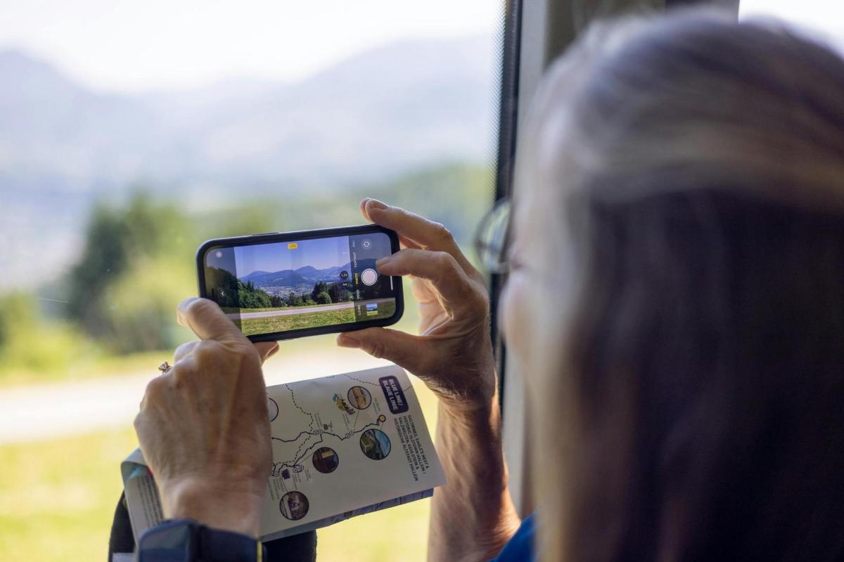 egy nő fényképez a mobiltelefonjával