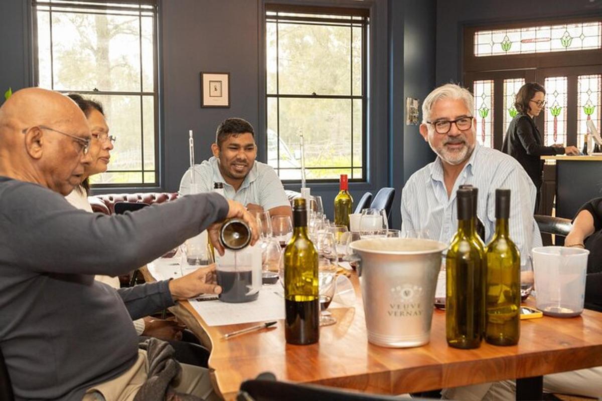 a group of people sitting around a table with wine bottles