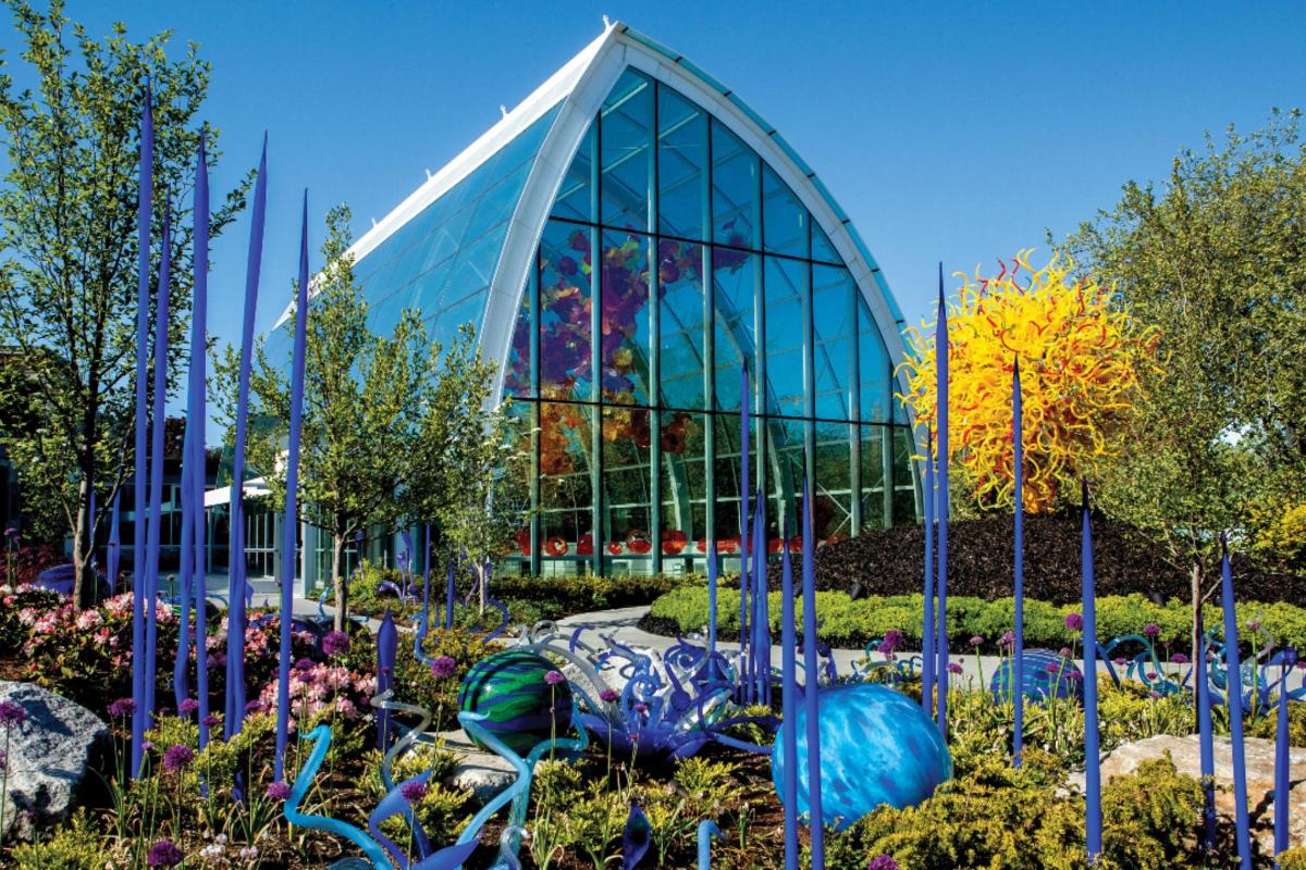 a glass building with a garden in front of it
