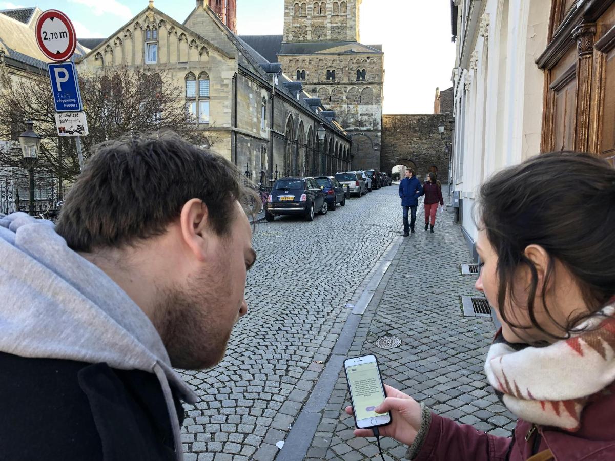 Un hombre y una mujer mirando un teléfono celular en una calle