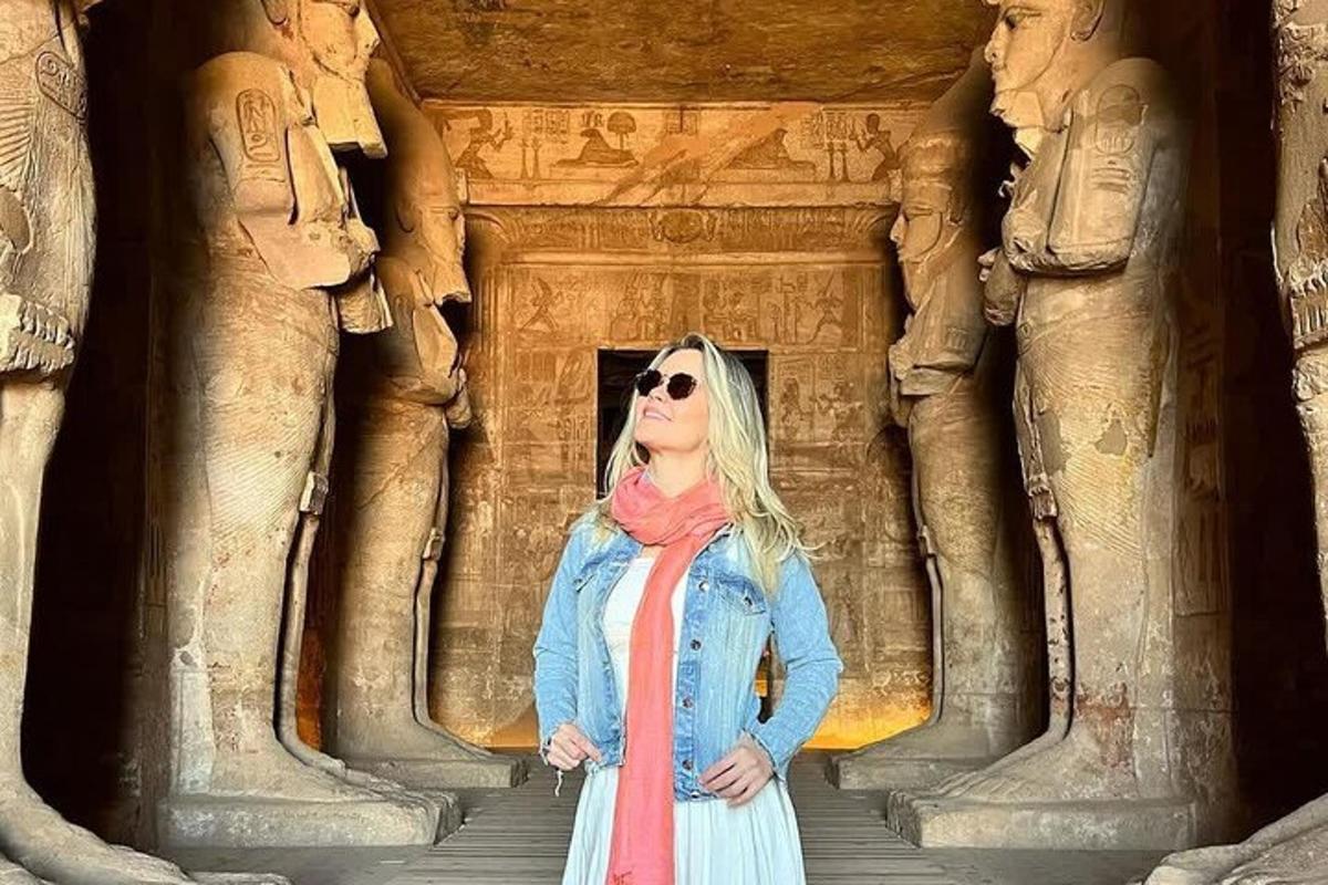 a woman standing in front of a building with statues