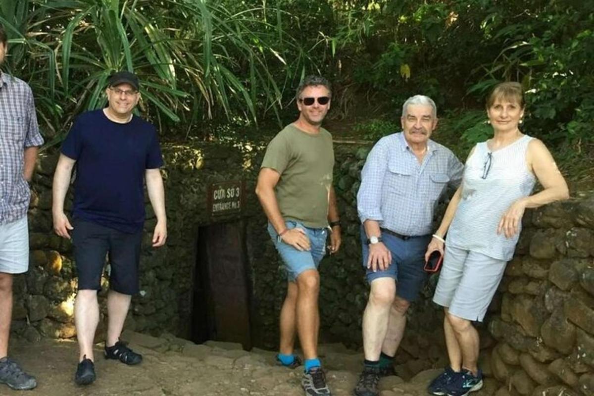 skupina ljudi, ki stojijo ob kamnitem zidu