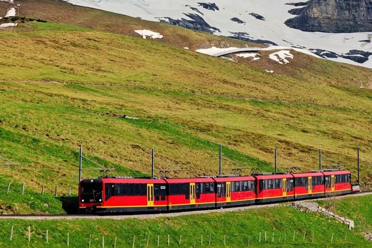 a red and yellow train traveling down a hill