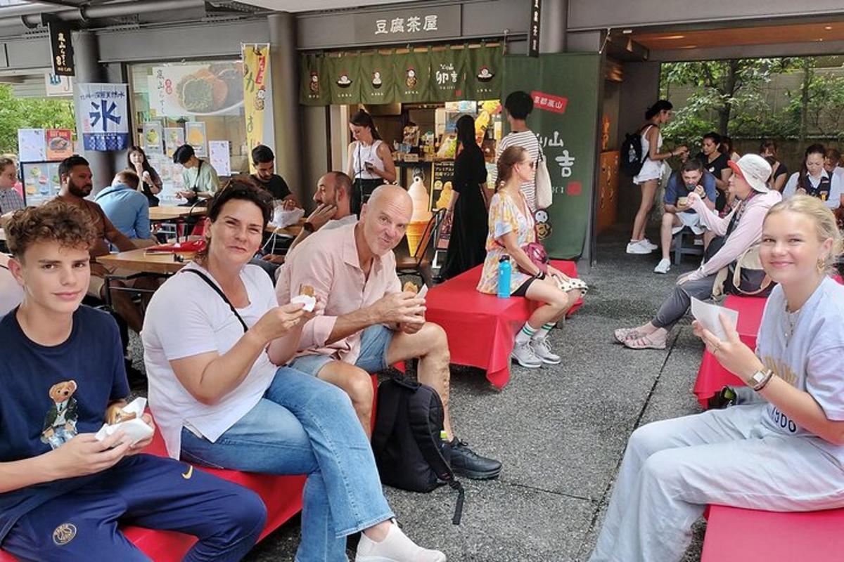 un gruppo di persone sedute su sedie rosse che mangiano cibo
