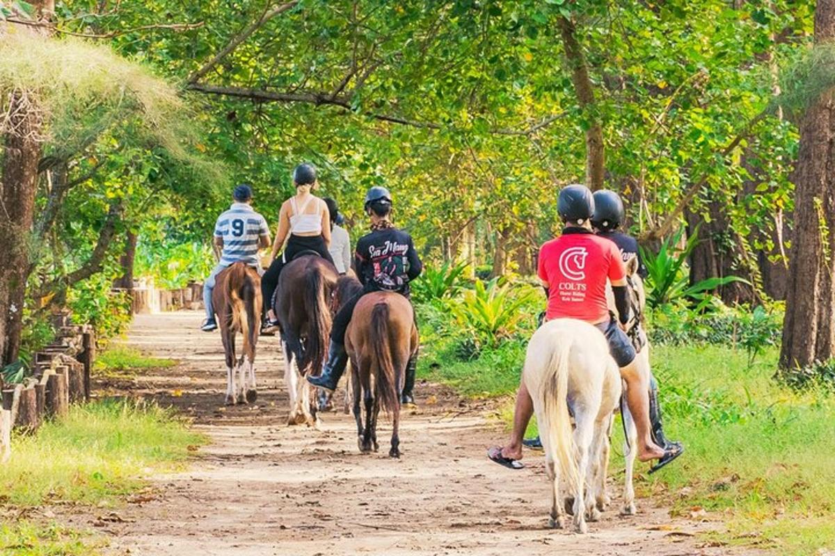 un grup de oameni călare pe cai pe un drum de pământ