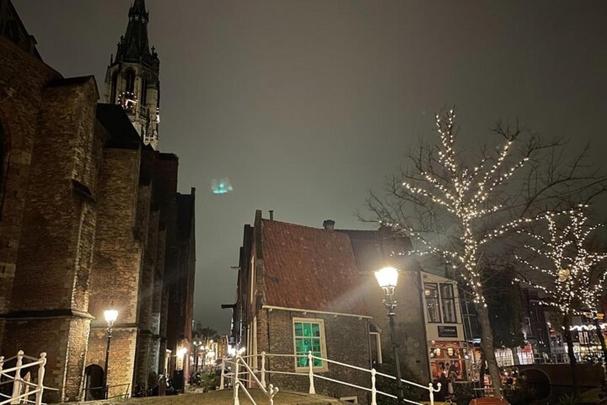 un edificio con una torre dell'orologio e un albero con luci