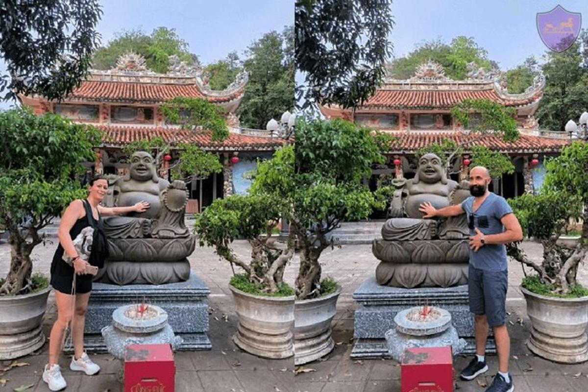 Dos personas de pie frente a estatuas frente a un edificio.