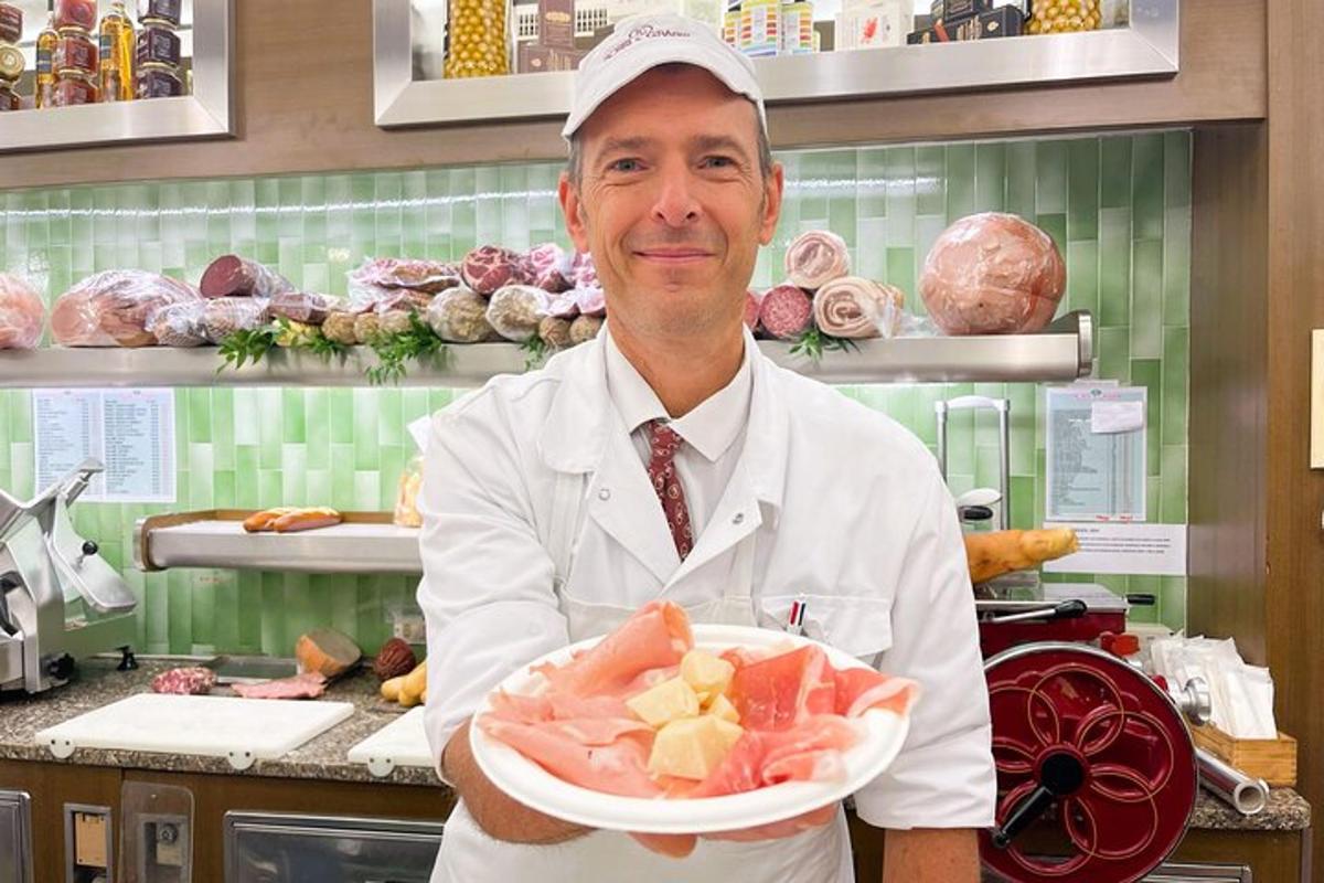 egy szakács egy tányér ételt tart a konyhában