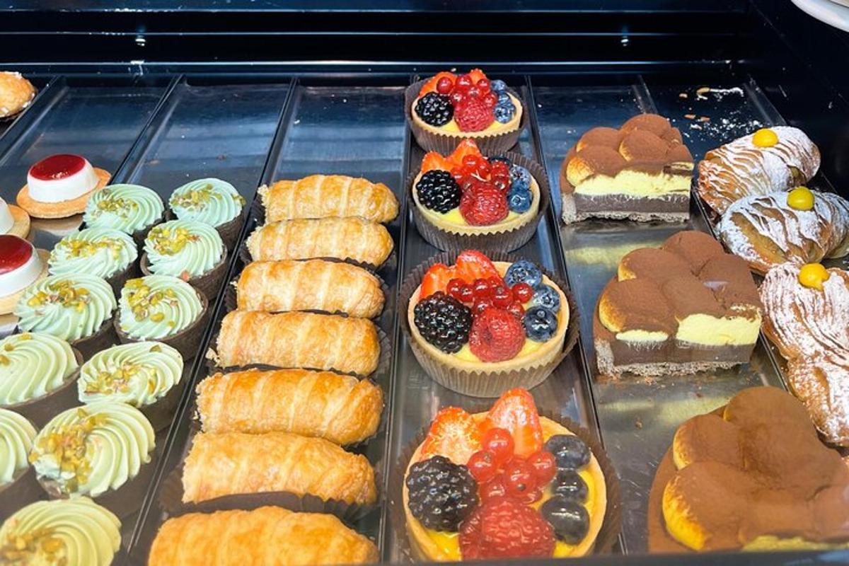 egy vitrin tele különféle péksüteményekkel és tortákkal