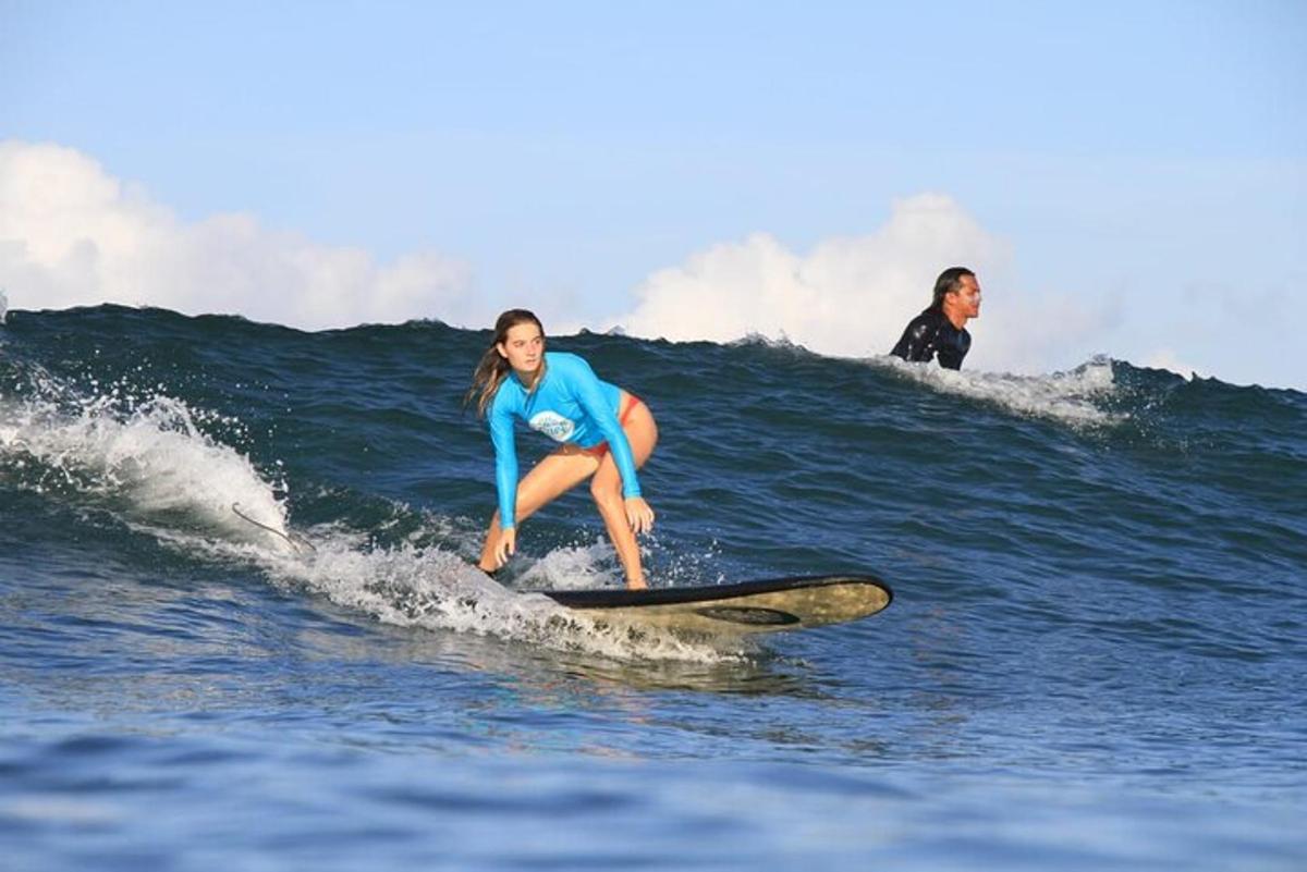 Dos mujeres montando una ola en una tabla de surf en el océano