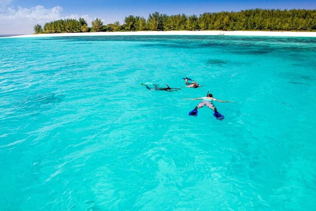 tre persone che nuotano in un grande specchio d'acqua